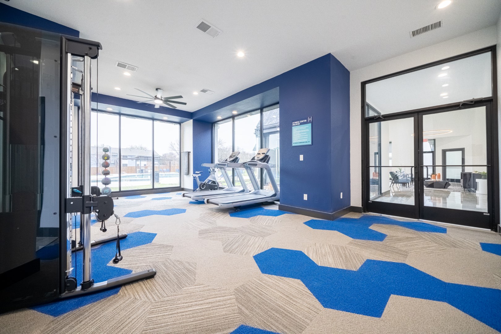 a gym room with blue carpet and blue walls at The Hendrix Apartments